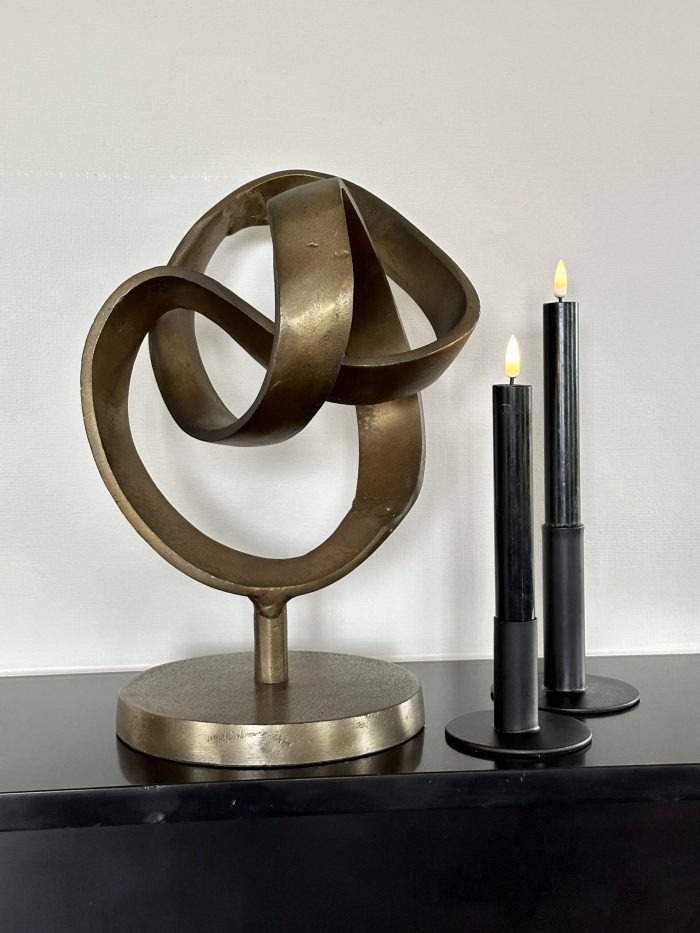 Abstract bronzen beeld op sokkel met LED-kaarsen op zwarte kast – moderne woondecoratie voor luxe interieur