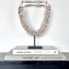 Exclusieve schelpenketting op standaard, ideaal als luxe woondecoratie of stijlvol accent op een dressoir of salontafel.