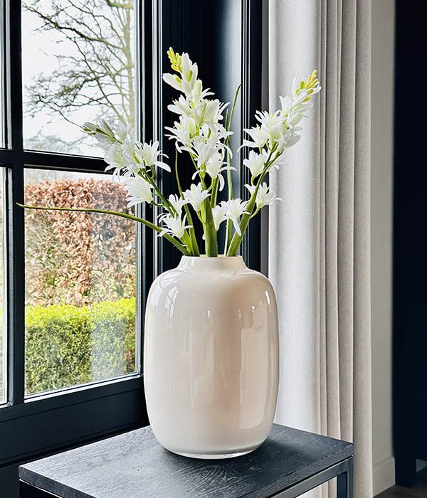 Artic S vaas pastel ivory van Vase The World, gestyled met bloemen op een bijzettafel