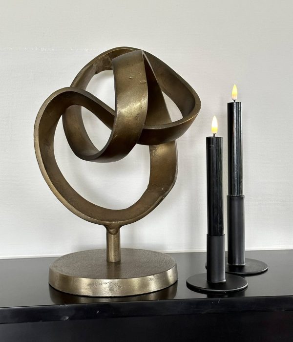 Abstract bronzen beeld op sokkel met LED-kaarsen op zwarte kast – moderne woondecoratie voor luxe interieur