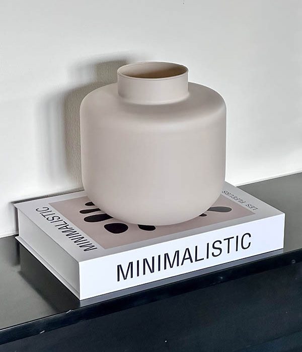 Jodeco Eco vaas Melanie in taupe – matte vaas op decoratief koffietafelboek met minimalistische styling