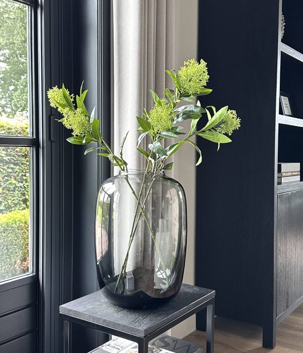 Close-up van de groene Zijden Skimmia Tak van Colours & Green, natuurgetrouwe kunstbloem met blad en bloemtrosjes.