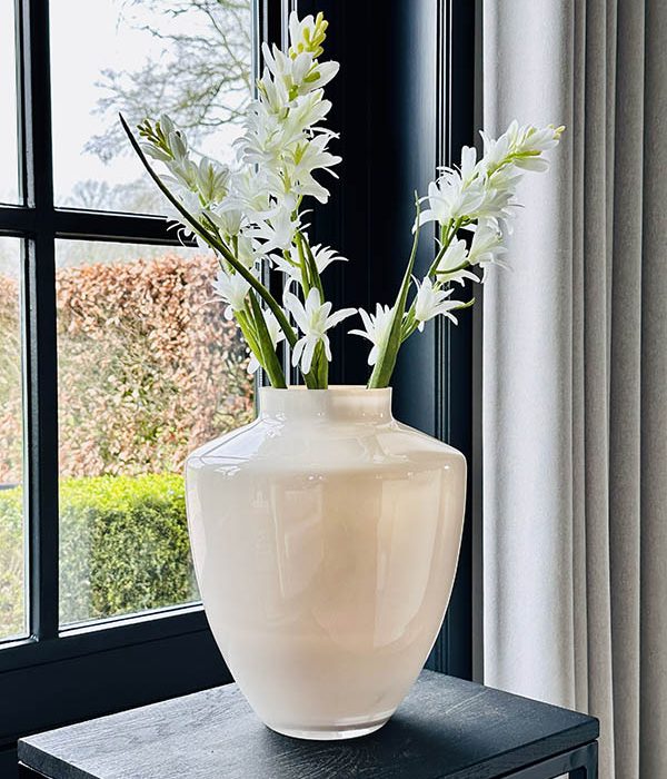 Tugela S vaas van Vase The World in pastel ivory, gestyled met bloemen op een houten bijzettafel