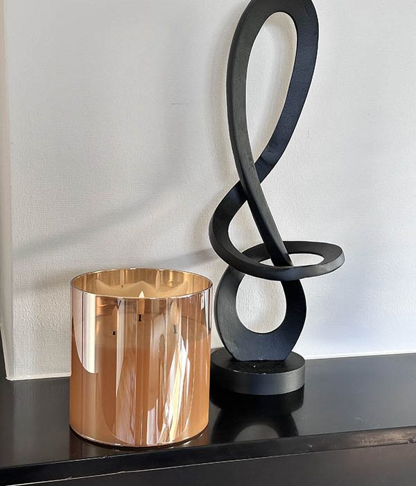 Countryfield LED kaars in goudkleurig glas met 3 lonten, gestyled naast zwart modern kunstobject