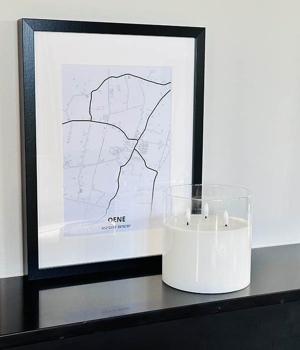 Countryfield LED kaars in helder glas met 3 lonten, gestyled naast ingelijste wanddecoratie in modern interieur