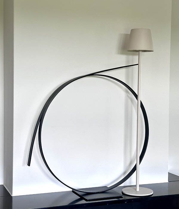 Zwart stalen ornament Cirque van 60 cm naast een lamp in modern interieur