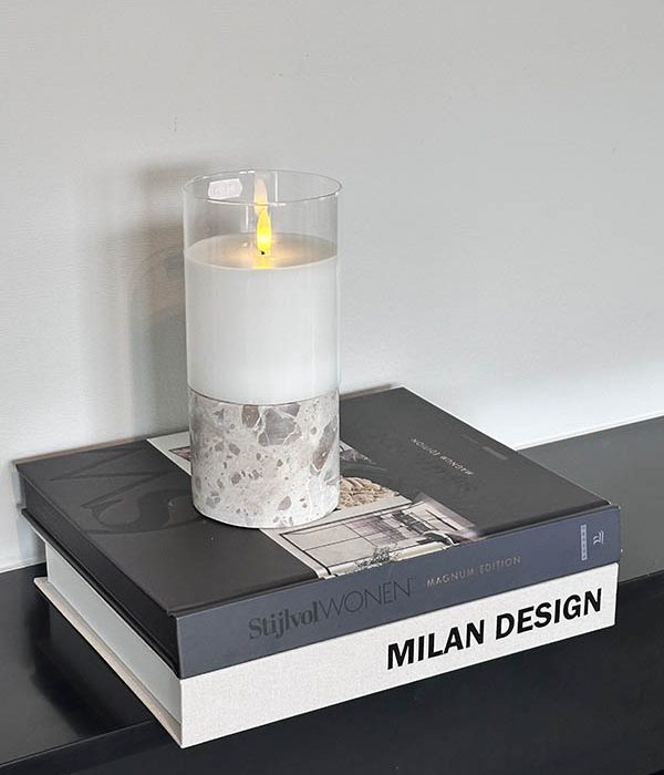 Travertin kaarsenhouder naturel met kaars op koffietafelboeken