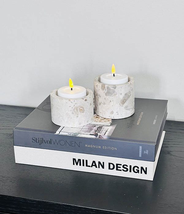 Travertin kaarsenhouder M en L naturel met kaars op koffietafelboeken
