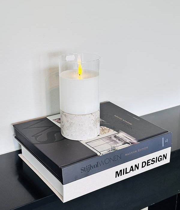 Travertin kaarsenhouder naturel M met kaars op koffietafelboeken